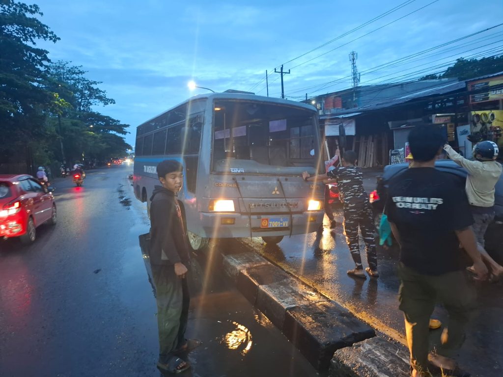 Personel Polri dan Warga Bersama Bantu Mobil Bus TNI AL Tabrak Pembatas Jalan